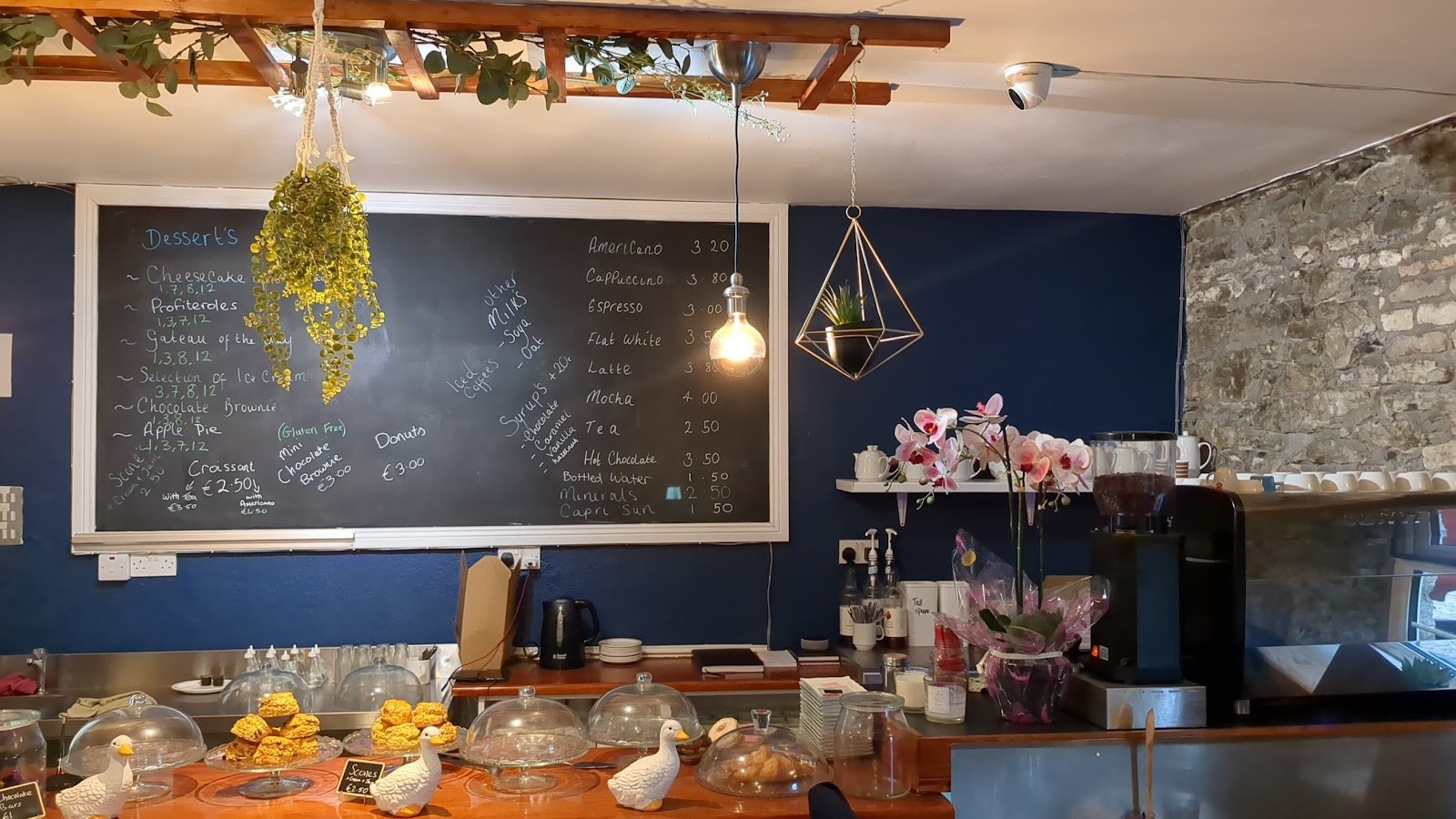 The chalkboard menu and scones under glass on the counter at The Crank Café